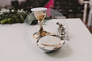 Goblet of wine on table during a wedding ceremony nuptial mass. Religion concept. Catholic eucharist ornaments for the celebration photo