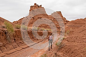 Goblin Valley - Woman walking along temporary mud river flowing down Goblin Valley State Park, Utah, USA