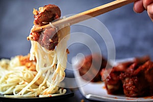 Gochujang ribs and noodles on dark cement background