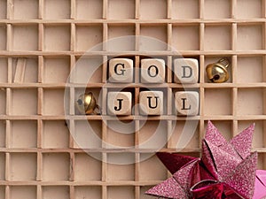 God Jul on small wooden blocks with a red Christmas decoration