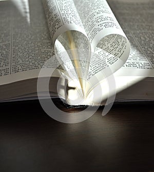 God is love, closeup pages of an open book, with heart shaped pages