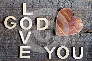 God is love letters with cross and heart religion concept on wooden background