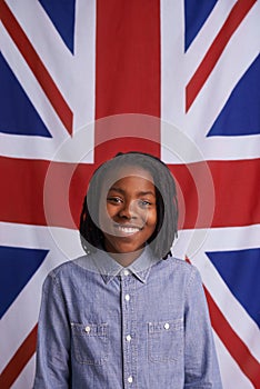 God save the queen. Portrait of a happy young boy standing in front of the Union Jack.