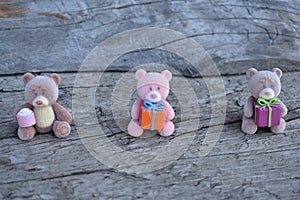 Three toy bears with gifts on the board photo