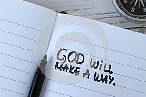 God will make a way, handwritten quote in notebook with compass