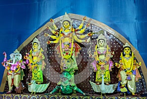 Goddess Durga idol at decorated Puja pandal, shot at colored light.