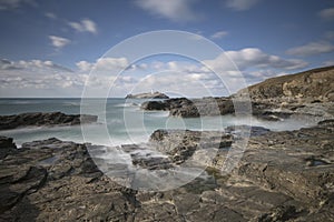 Godrevy Lighthouse on Godrevy Island in St Ives Bay with the beach and rocks in foreground, Cornwall uk