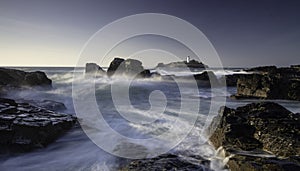 Godrevy Lighthouse on Godrevy Island in St Ives Bay, Cornwall, UK with crashing waves and rocks