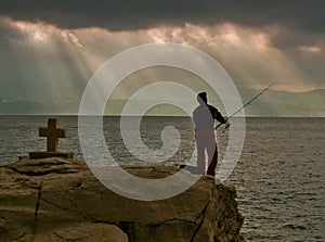 Gods rays, cross and fisherman