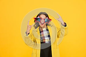She goes crazy. Crazy child show horns sign hand gesture. Happy girl with crazy look yellow background. Fashion kid wear