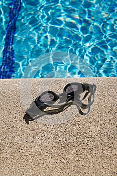 Goggles on curb of swimming pool