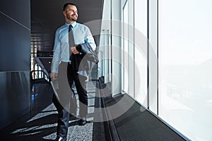 Going above and beyond. an executive businessman walking through an airport during a business trip.