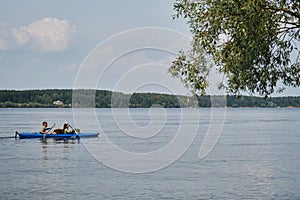 Going kayak boating with dogs on river, active pets concept, happy dog and owner on adventure. Young couple with dreadlocks having