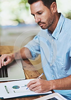 Going over the numbers. a businessman working on his laptop at home.