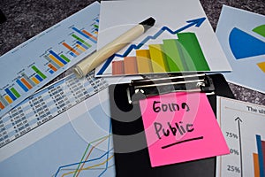 Going Public write on sticky notes isolated on Office Desk. Stock market concept