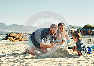 We going to build a big sand castle together. a young family spending quality time at the beach.
