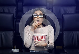 Going to movies alone. Scared Asian woman in 3D glasses watching thriller in cinema photo