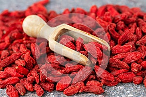 Goji berries close-up. Wooden scoop with dried goji berries, selective focus