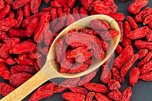 Goji berries in wooden spoon. Top view, flat lay