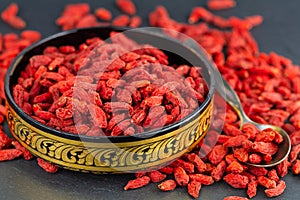 Goji berry in gold cup in closeup. Selective focus