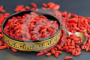 Goji berry in gold east bowl in close-up. Selective focus