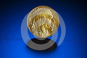 Gold $ 50. Indian head 1 oz. American coin on blue