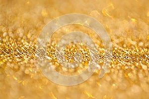 Gold abstract bokeh glitter texture background, filled with shiny gold glitter background. selective focus