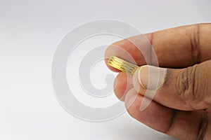 Gold band rings for men and women held in the hand on a white background