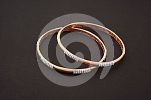 gold bangle jewelry with white diamonds isolated on brown background