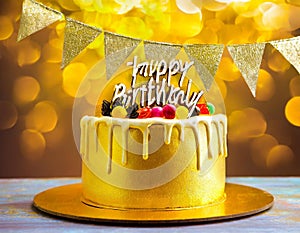 A gold banner with a happy birthday message decorates the birthday cake