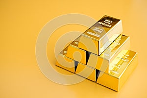 Gold bars or bullion stack on yellow background. Financial, global world economic or gold trading in commodity market concept.