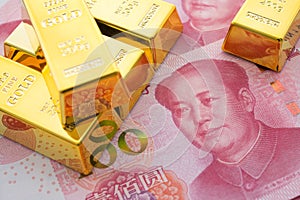 Gold bars on Chinese yuan bill banknotes background. Concept of gold future trading, online asset commodity trading