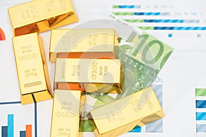 Gold bars and euro banknotes on documents