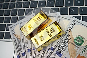 Gold bars notebook and dollars .Concept of gold futures trading, online asset trading or buying gold bars for investment