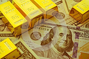 Gold bars on US dollar bill banknotes background. Concept of gold future trading, online asset commodity trading or buy gold bars