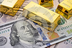 Gold bars on US dollar bill banknotes background. Concept of gold future trading, online asset commodity trading or buy gold bars