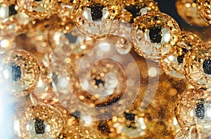 Gold beads in the wine glass with water, bubbles, macro, photo, background for design