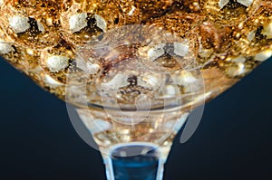 Gold beads in the wine glass with water, bubbles, macro, photo, background for design