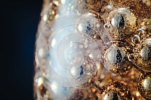Gold beads in the wine glass with water, bubbles, macro, photo, background for design