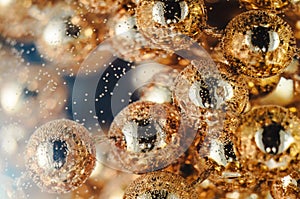 Gold beads in the wine glass with water, bubbles, macro, photo, background for design