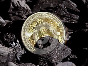 Gold bitcoin on a coal`s background. Mayerized Crypto currency. Payroll through the Internet. To drip crypto currency bitcoin. The