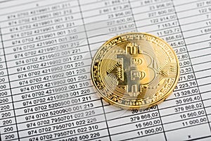 Gold bitcoin coin on numbers