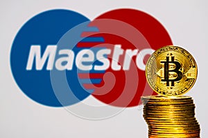 Gold Bitcoin coins with the maestro logo on background