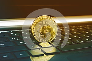 ..Gold bitcoin cryptocurrency with a latop computer