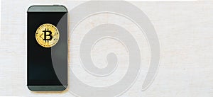 Gold bitcoin cryptocurrency with phone