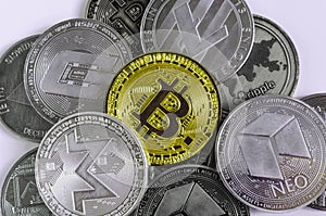 Gold bitcoin dominates the background of coins of various cryptocurrencies  on a white background