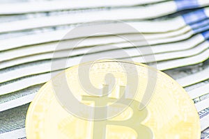 Gold Bitcoin on hundred dollars bills. Golden symbolic coin Bitcoin on banknotes of one hundred dollars. Cryptocurrency