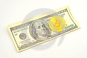 Gold Bitcoin on hundred dollars bills. Golden symbolic coin Bitcoin on banknotes of one hundred dollars. Cryptocurrency