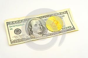 Gold Bitcoin on hundred dollars bills. Golden symbolic coin Bitcoin on banknotes of one hundred dollars. Cryptocurrency
