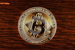 Gold Bitcoin physical coin on wooden Background. Shining digital currency coin. Cryptocurrency digital currency. Bitcoin coin.